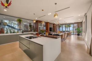 an open kitchen and dining room with a large island at The Five Stars Villa 6 Bedrooms Beachfront in Danang