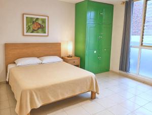 a bedroom with a bed and green cabinets at Jardin 85 Boutique Hostel in Morelia +77 photos