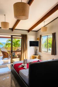 a bedroom with a bed and a view of the ocean at Sunset Palms Rarotonga in Rarotonga