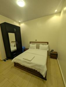 a bedroom with a large bed and a mirror at EDEN PALACE KIGALI AIRPORT AND APARTMENTs in Kigali