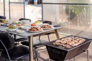 a table with plates of food and a grill at Muuido Haedungsil Pension in Incheon