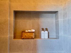 two bottles on a shelf in a bathroom at Casa Frida in Valle de Guadalupe