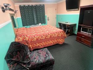 a bedroom with a bed and a desk and a television at Evans Motel in Maywood