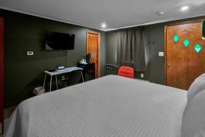 a bedroom with a bed and a desk and a television at Berkshire Lake Lodge in Becket