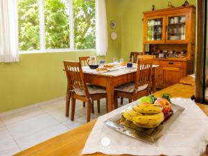 a dining room with a table with a plate of fruit at Pousada Casa do Reiki - Rancho Queimado/SC in Rancho Queimado