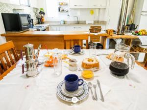 a table with a white table cloth with food on it at Pousada Casa do Reiki - Rancho Queimado/SC in Rancho Queimado