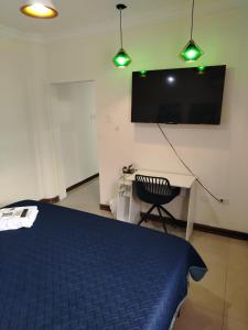a bedroom with a bed and a desk and a tv at Casa Florencia Hab 1 Florencia in Guayaquil