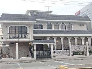 a white building with a balcony on a street at Casa Florencia Hab 1 Florencia in Guayaquil +2 photos
