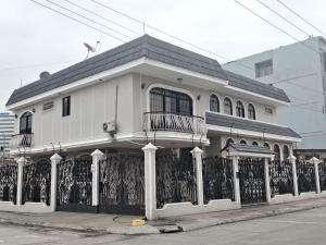 a white house with a fence in front of it at Casa Florencia Hab 1 Florencia in Guayaquil