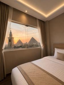 a bedroom with a window with a view of the pyramids at Royal Aida Pyramids View INN in Cairo
