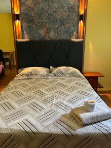 a bed with a black headboard with a bowl on it at Hostal La Huerta in Huánuco +10 photos