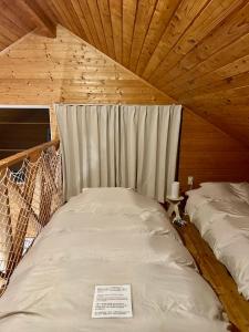 a room with two beds in a wooden ceiling at Tokachi Mikage forest villa in Mikage