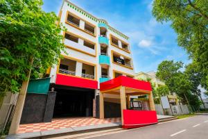 a building with red and whitefacades on a street at Hotel O Aarshi Palace in Cuttack