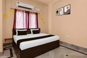 a bedroom with a bed and a window at Hotel O Aarshi Palace in Cuttack