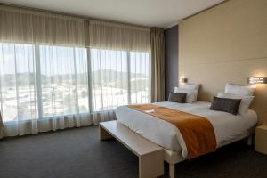 a hotel room with a bed and a large window at Hôtel du Centre Appart hôtel Business avec Parking Gratuit à Nouméa in Noumea +164 photos
