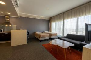 a living room with a couch and a table at Hôtel du Centre Appart hôtel Business avec Parking Gratuit à Nouméa in Noumea
