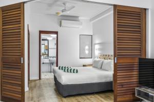 a bedroom with a bed and a bathroom at Silkari The Pavilions in Port Douglas +19 photos