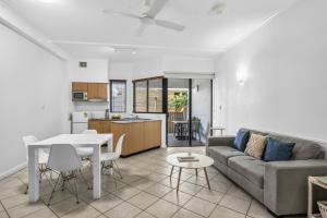 a living room and kitchen with a couch and a table at Silkari The Pavilions in Port Douglas