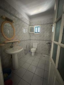 a white bathroom with a sink and a toilet at maison de charme in Fafou