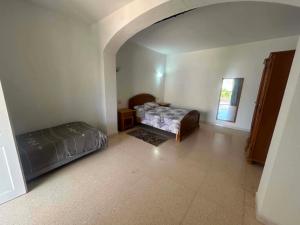 a bedroom with two beds in a room with an arch at maison de charme in Fafou