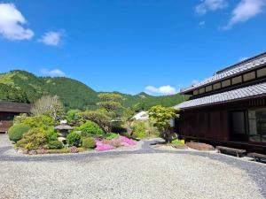 a gravel driveway in front of a building with a garden at 茶室山谷庵 in Gero