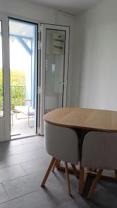 a wooden table and chairs in a room with a balcony at Maya Dream in Morne Blanc