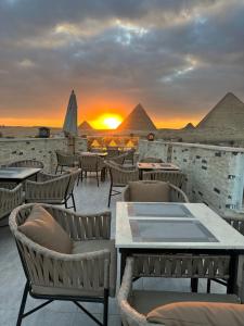 a restaurant with a view of the pyramids at sunset at Royal Aida Pyramids View INN in Cairo +15 photos