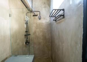 a bathroom with a shower with a toilet and a glass door at Iron Wave Uluwatu in Bingin Beach