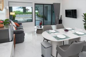 a living room with a white table and a couch at Turtle Tales-Tao Kra in Thai Muang