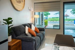 a living room with a couch and a sliding glass door at Turtle Tales-Tao Kra in Thai Muang