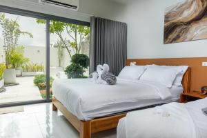 a bedroom with a bed with two stuffed animals on it at Turtle Tales-Tao Kra in Thai Muang +56 photos