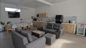 a living room with two couches and a kitchen at Villa Segara Agung Amed in Amed