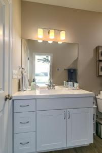 a bathroom with a sink and a large mirror at Chic Townhome near LA Tech in Ruston +65 photos
