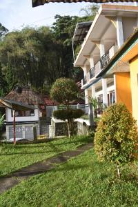 a building with a grass yard next to a house at Bajawa-Roo Hotel in Bajawa