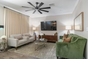 a living room with two couches and a flat screen tv at Chic Townhome near LA Tech in Ruston
