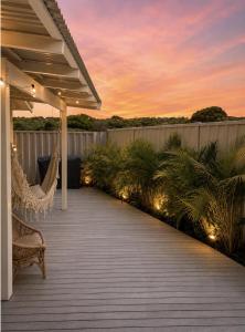 a deck with a chair and lights at sunset at Blueholes Beach Villa - Private Outdoor Space in Kalbarri