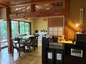 a kitchen with a dining room with a table and chairs at Yamaneko Lodge in Gujo
