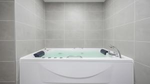 a bath tub with a faucet in a bathroom at Gapyeong Haneulsup Spa Pension in Gapyeong +12 photos