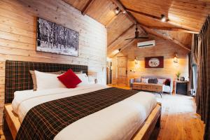 a bedroom with a large bed in a room with wooden walls at AMAYA HOME - Lodge, Spa & Restaurant Sóc Sơn in Sóc Sơn