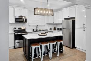 a kitchen with white cabinets and a kitchen island with stools at Villa del Nique in Pembroke