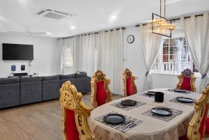a dining room with a table and chairs and a couch at Villa del Nique in Pembroke