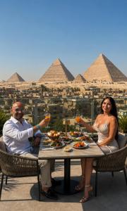 a man and woman sitting at a table with wine glasses at Royal Aida Pyramids View INN in Cairo