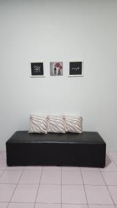 a black bed with three pictures on a wall at 338 House in Ban Liam