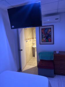 a bedroom with a bathroom with a sink and a toilet at Hospedaje Lima Suite in Piura