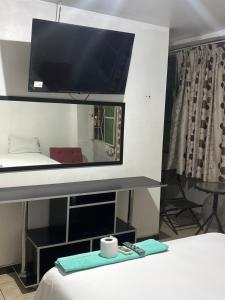 a room with a tv on the wall and a bed at Hospedaje Lima Suite in Piura