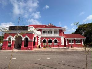 a red building with a red roof on a street at Hotel & Recreation Apsara Bukit Residen in Kuala Lipis