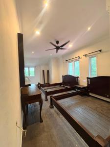 a room with several wooden tables and a ceiling fan at Hotel & Recreation Apsara Bukit Residen in Kuala Lipis