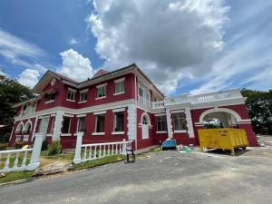 a red and white house with a white fence at Hotel & Recreation Apsara Bukit Residen in Kuala Lipis