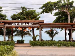 a cafe kete and bar with the ocean in the background at Klang Aow Resort in Khanom