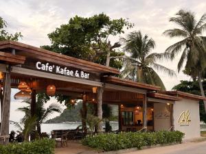 a cafe kakeka and bar with tables and chairs at Klang Aow Resort in Khanom
